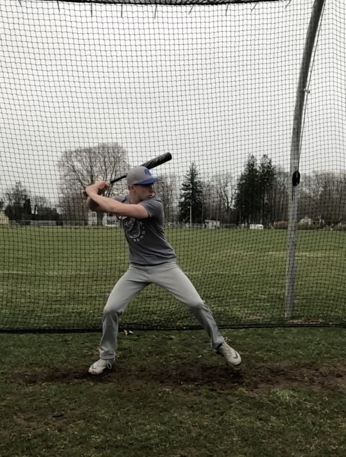 Jack in high school, taking batting practice in the cage with focused intensity